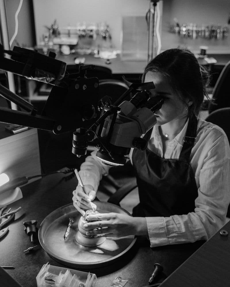 Jewellery professional inspecting a gemstone under a microscope